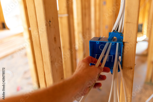 Hand working on electrical wires in new home construction