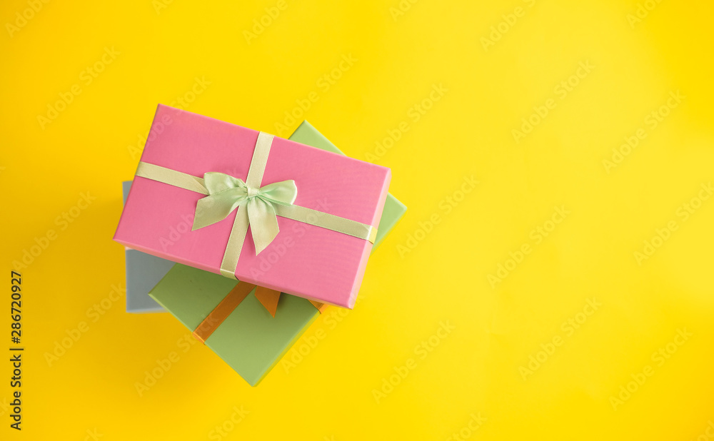 Gift box on sunny yellow background. The concept of the New Year, Christmas, Birthday, Anniversary. Top view. Flatlay. Gift box on sunny yellow background. The concept of the New Year, Christmas, Birthday, Anniversary. Top view. Flatlay.
