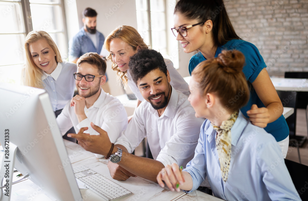 Group of business professionals having a meeting. Diverse group of designers smiling at the office.