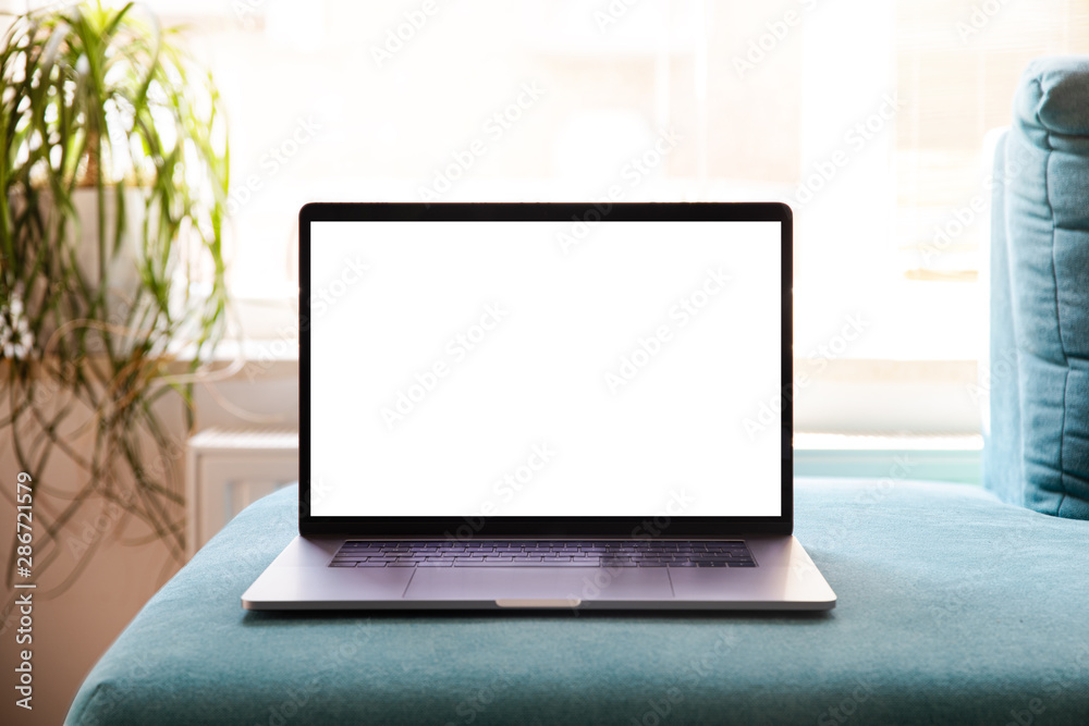 Laptop with blank screen on sofa in livingroom Laptop with blank screen on sofa in livingroom