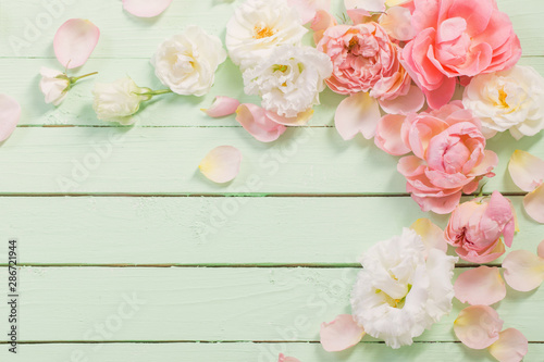 pink and white roses on green wooden background © Maya Kruchancova