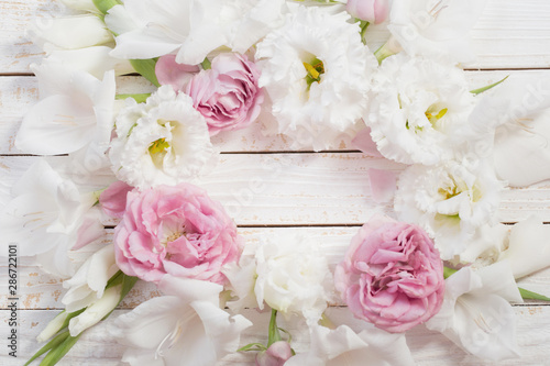 pink and white flowers on white wooden background © Maya Kruchancova
