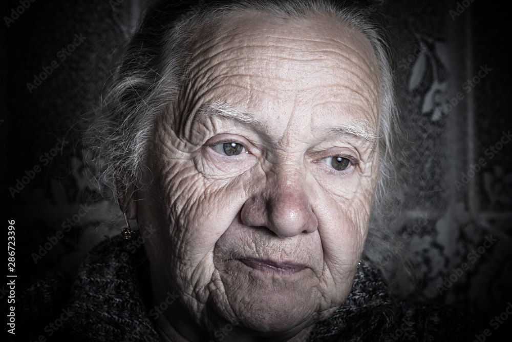 Portrait of elderly woman in rustic interior. Toned Portrait of elderly woman in rustic interior. Toned