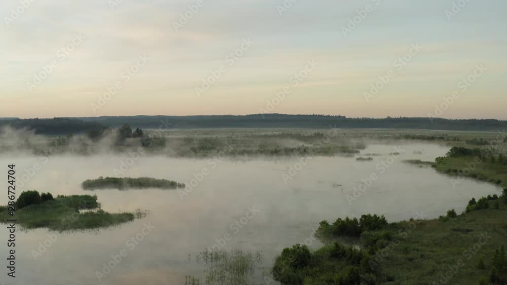 Misty and dark swamp with islands in the Morning, aerial sunrise