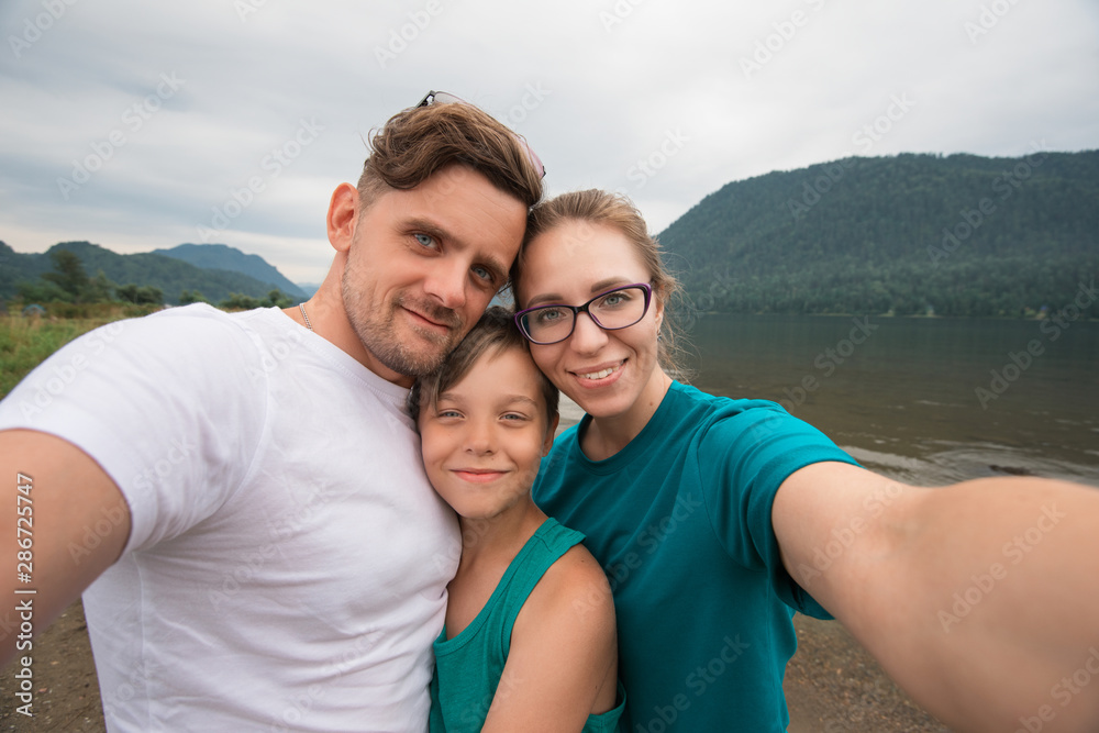 Selfie of family on the Teletskoye lake in Altai mountains, Siberia, Russia. Beauty summer day.