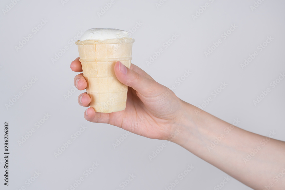 Side profile cropped close up photo of hand getting holding sharing taking waffle cup with ice cream isolated grey background Side profile cropped close up photo of hand getting holding sharing taking waffle cup with ice cream isolated grey background