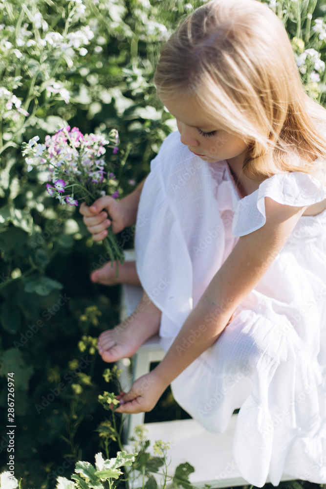 Close up portrait of little cheerful girl in flower summer field. Childhood, nature concept Close up portrait of little cheerful girl in flower summer field. Childhood, nature concept