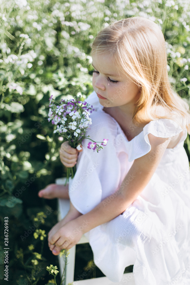 Close up portrait of little cheerful girl in flower summer field. Childhood, nature concept Close up portrait of little cheerful girl in flower summer field. Childhood, nature concept