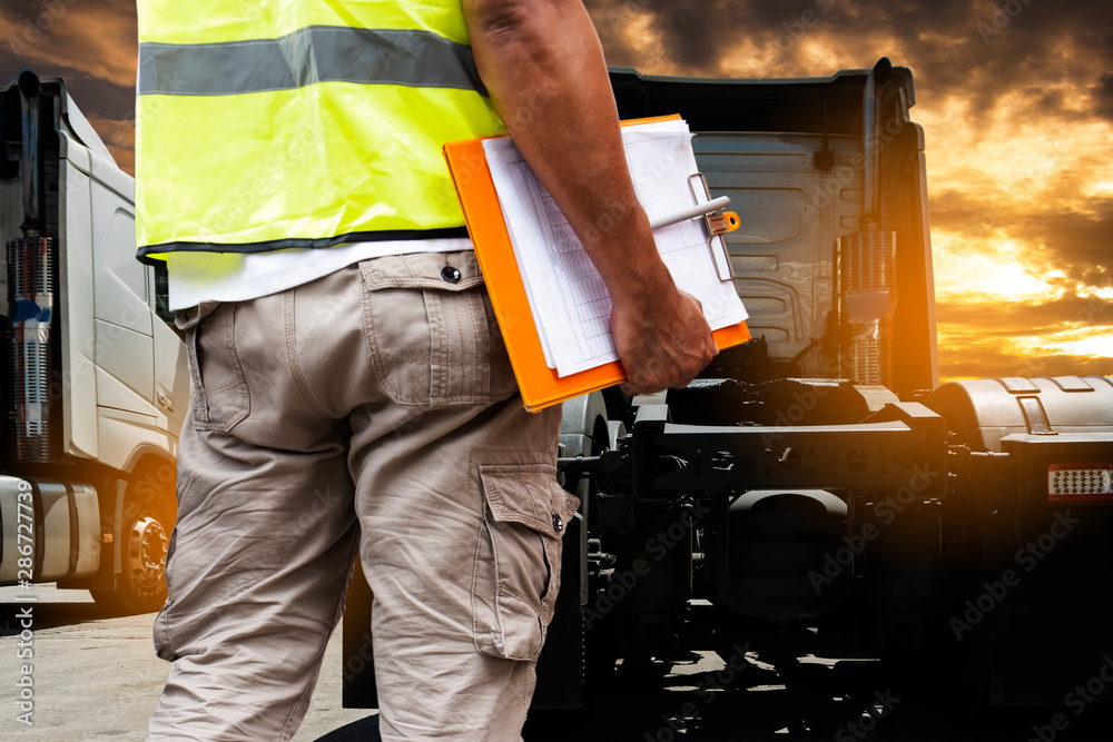 Auto Mechanic is Checking the Truck's Safety Maintenance Checklist. Inspection Safety of Semi Truck Wheels Tires. Auto Mechanic is Checking the Truck's Safety Maintenance Checklist. Inspection Safety of Semi Truck Wheels Tires.