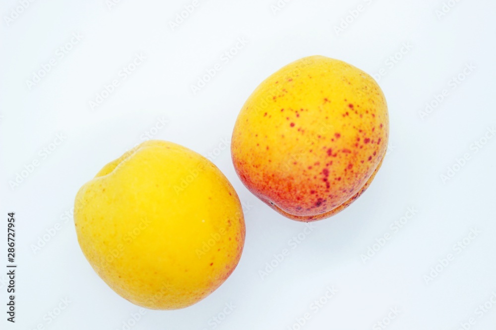 Delicious juicy apricots are located on a white background Delicious juicy apricots are located on a white background