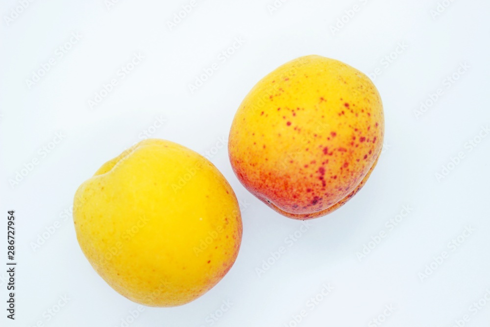 Delicious juicy apricots are located on a white background