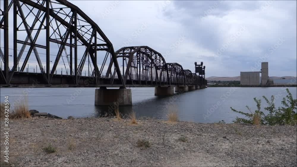 railroad bridge over river on cloudy day railroad bridge over river on cloudy day