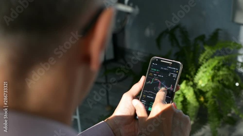 Bitcoin market, crypto trading online, trader working with a mobile phone on cryptocurrency exchange. Man touching screen, browsing market data, chart. Crypto currency. Bitcoin cryptocurrency.