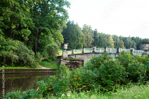 old vintage bridge on river in green park, landscape historical