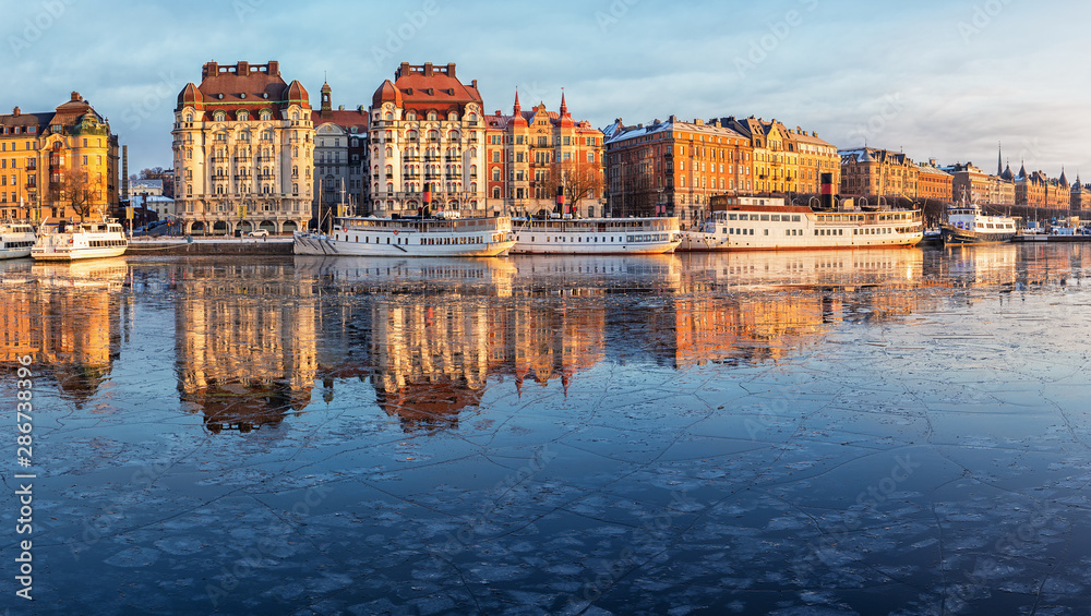 Stockholm waterfront with old architecture reflecting in the frozen bay in winter. - obrazy, fototapety, plakaty 
