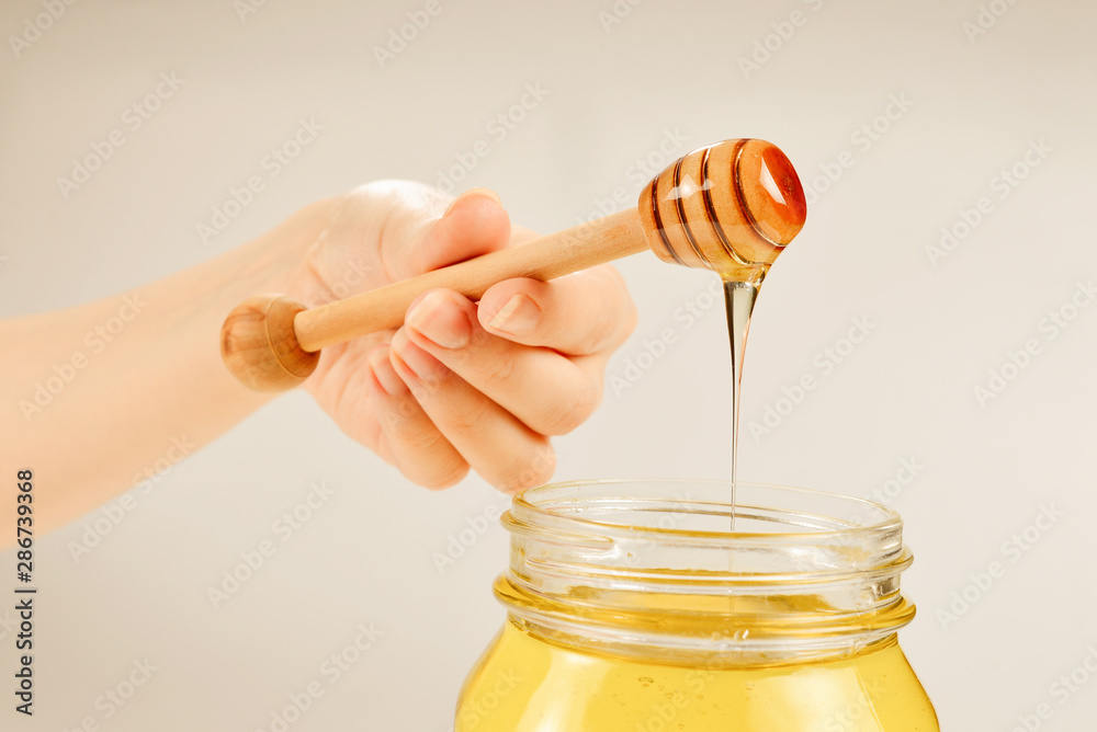 Dipper with honey in woman hand. Space for text or design. Dipper with honey in woman hand. Space for text or design.