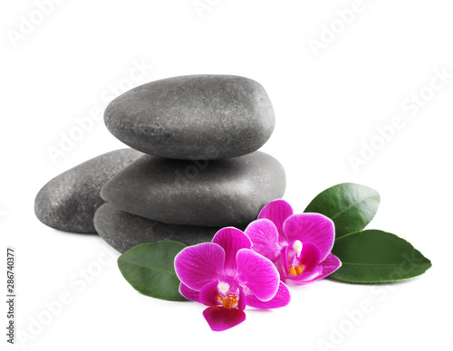 Pile of spa stones and orchid flowers on white background