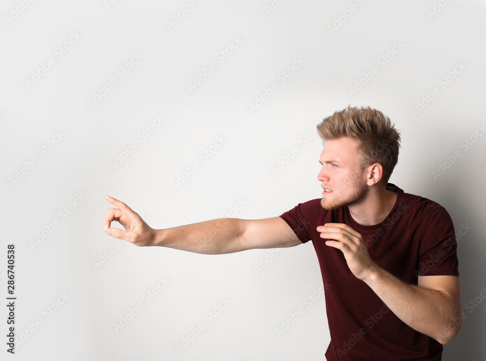 Young man outstretching hand on light background. Vision problem Young man outstretching hand on light background. Vision problem