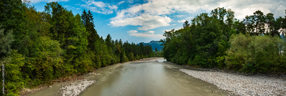 Panorama Fluss im Wald vor Bergkulisse