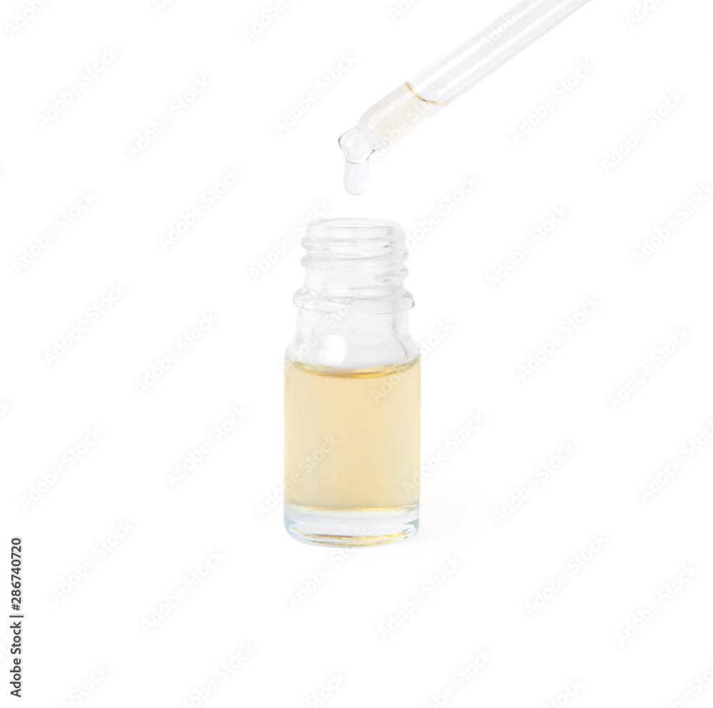 Woman dripping essential oil from pipette into glass bottle on white background Woman dripping essential oil from pipette into glass bottle on white background