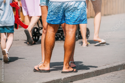man in shorts stands on the sidewalk in the city