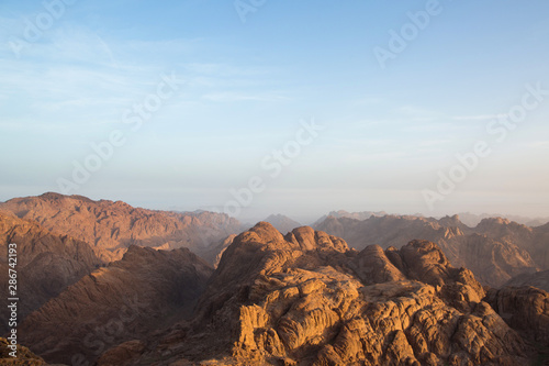 Dawn high in the mountains. The sun illuminates the peaks. Sunrise in the desert. Egypt. Mount Sinai, Mount Moses