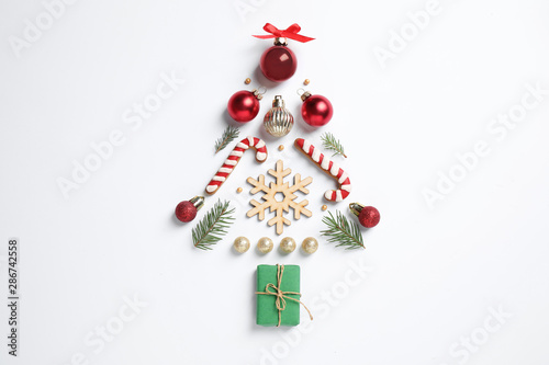 Christmas tree silhouette of fir branches and festive decoration on white background, top view