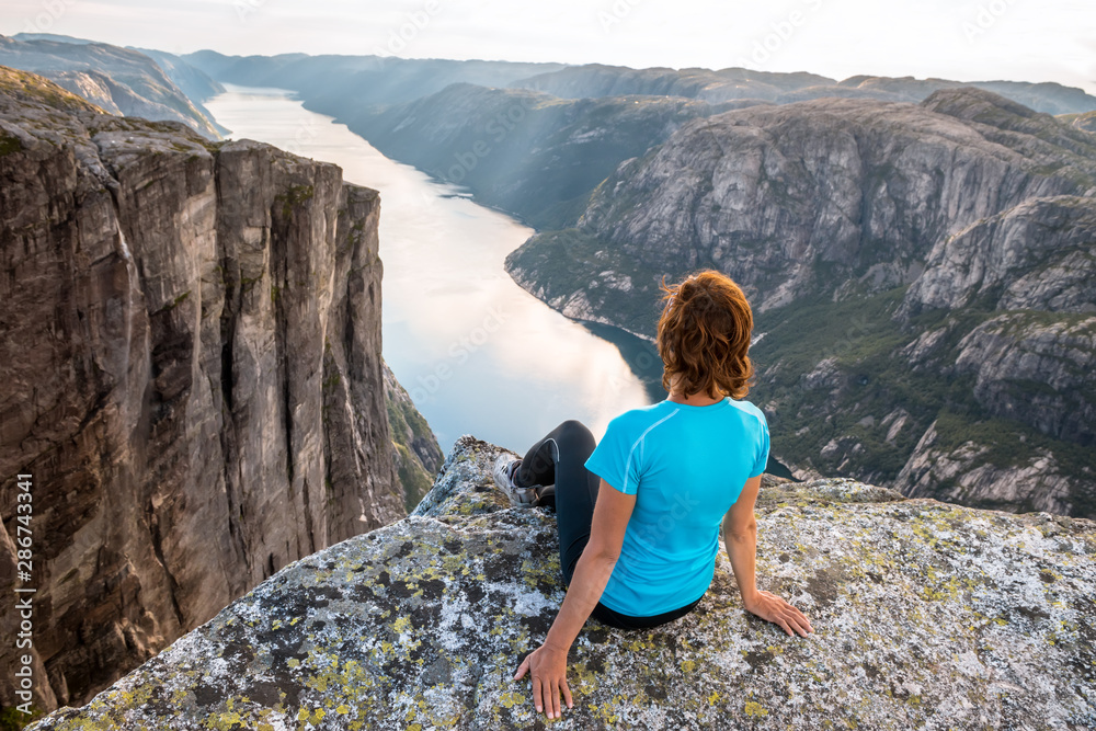 Sporty woman on the top of fjord near Kjeragbolten, Norway. Relax, success, motivation concept