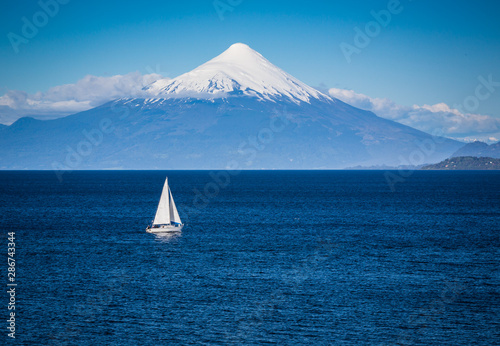 Modern sailboat sails in front of Osorno Volcano