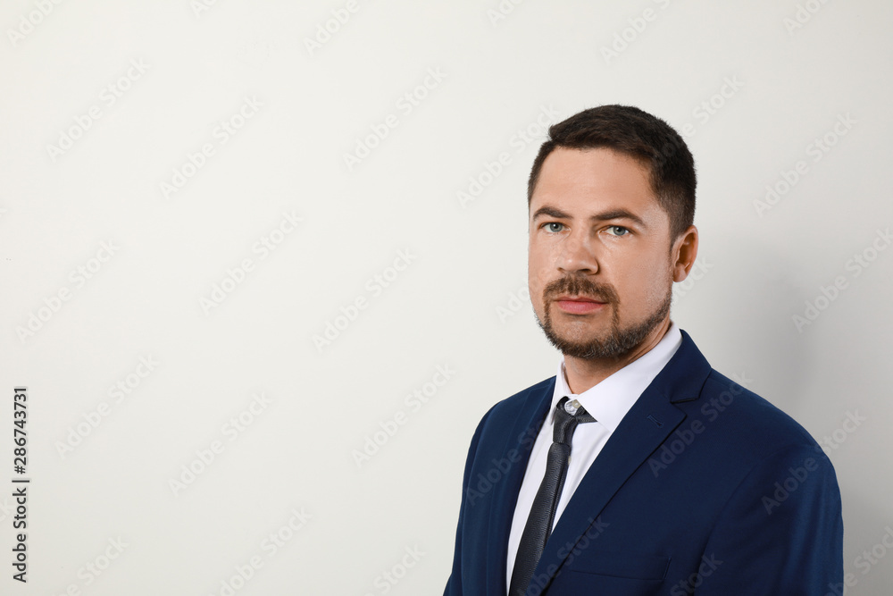 Portrait of handsome man in suit on light background. Space for text Portrait of handsome man in suit on light background. Space for text