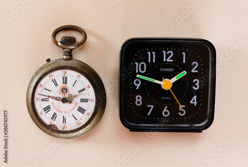 two clocks from different periods/two watches from different eras, one with mechanical charge and one with battery