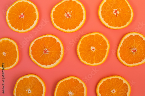 Background of ripe oranges cut on pink background