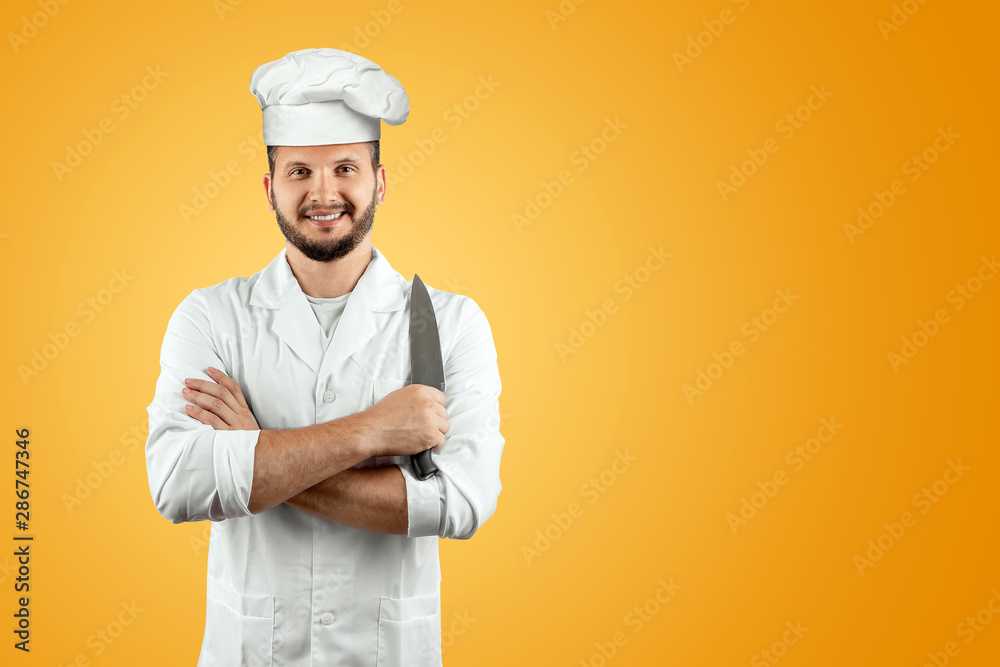 Man with a beard, a cook in a hat and a knife in his hand Isolated on a yellow background. Cooking, recipes, cuisine.