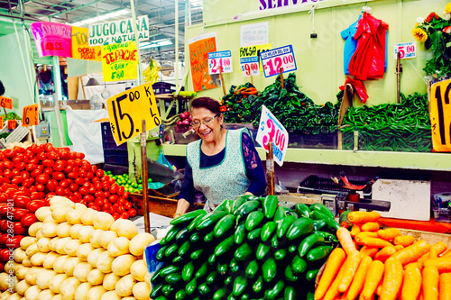 Candid portrait of cheerful woman at her vegetable stall photo