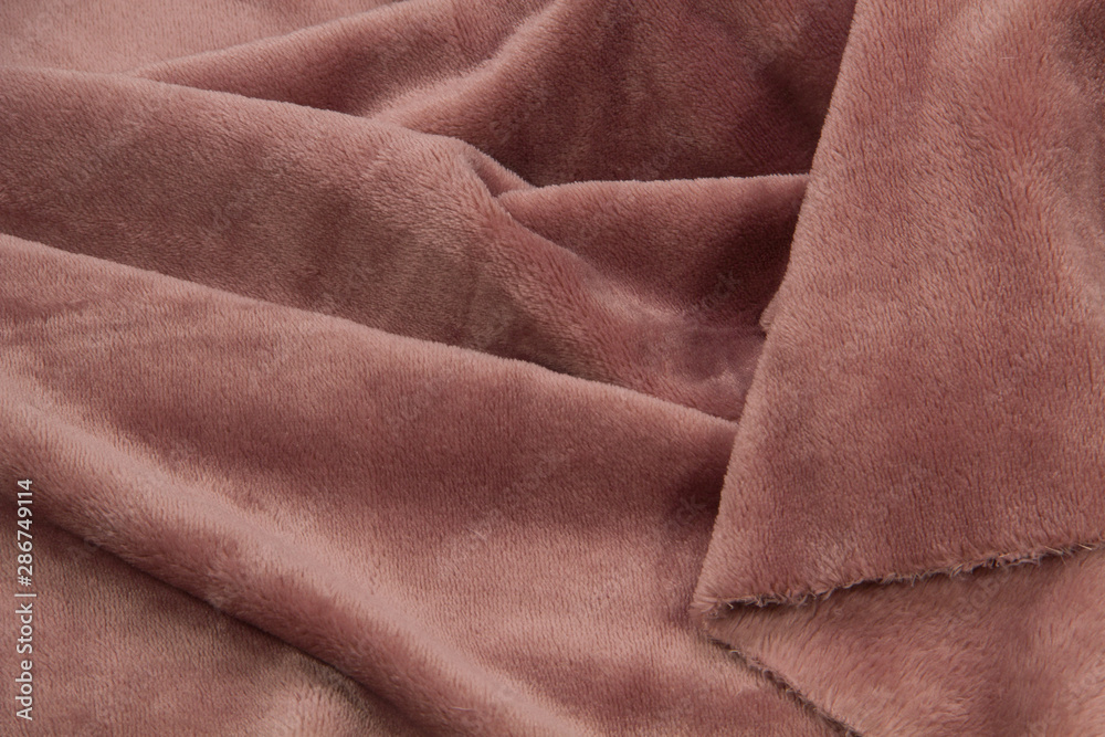 Fototapeta premium The blanket of furry fleece fabric. A background soft plush fleece material with a lot of relief folds