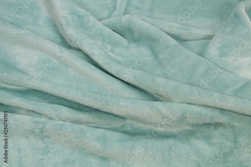 The blanket of furry fleece fabric. A background soft plush fleece material with a lot of relief folds