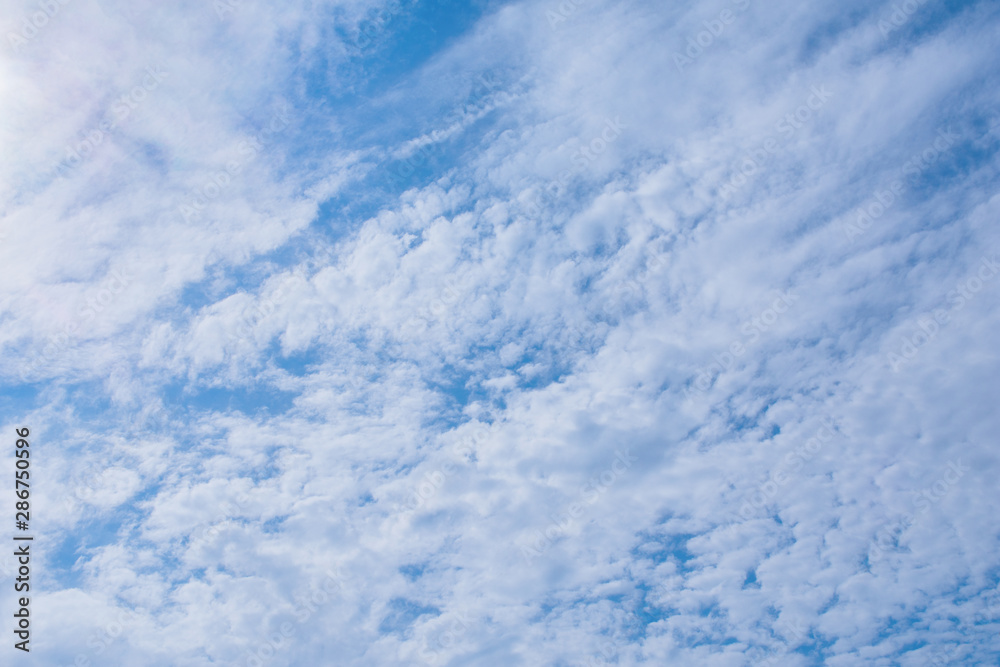 White, fluffy clouds in blue sky. Background from clouds. Clear blue sky with white clouds background.