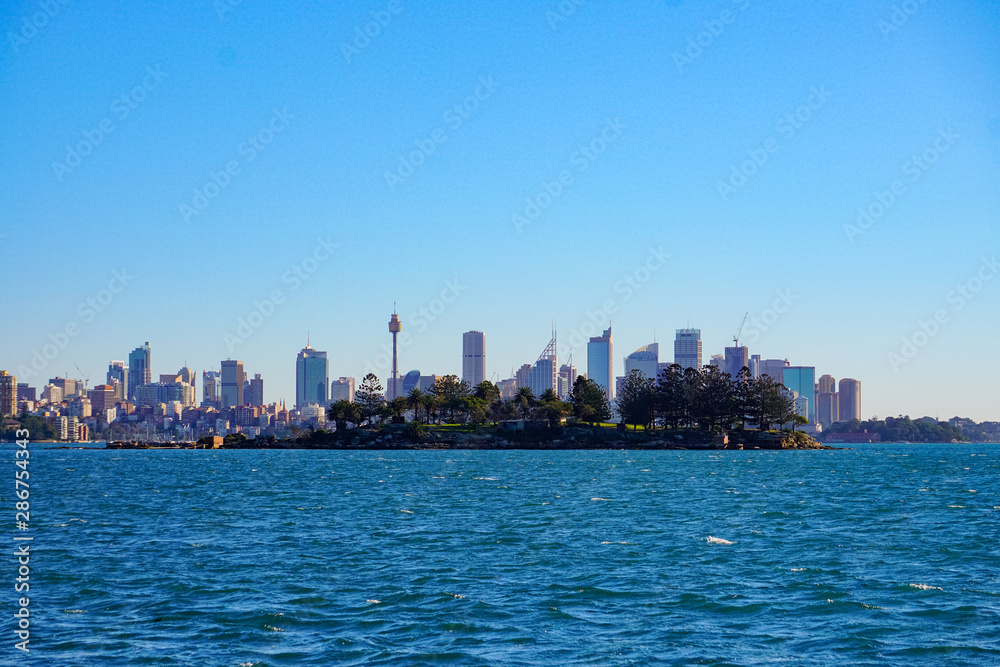 Australia sydney city CBD view from Cremorne point over blue harbour waters under clear sky