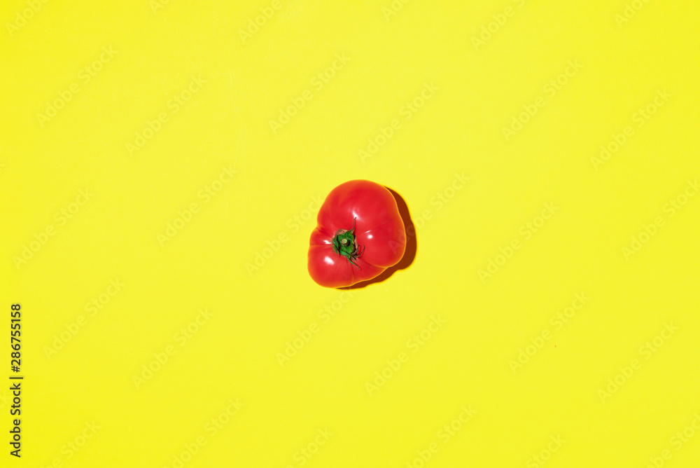 Fototapeta premium Red tomato on yellow background with copy space. Top view. Flat lay. Summer minimal concept. Vegan and vegetarian diet