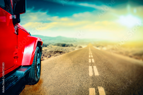 Red car on the road with sunset view.