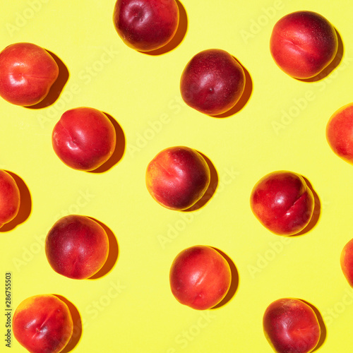 Nectarines pattern on yellow background. Frame made of fresh fruits. Flat lay, top view, copy space. Vegan and vegetarian diet