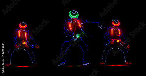 Dancers in led suits on dark background, Entertainment © VlaDee