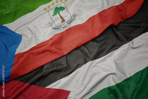 waving colorful flag of palestine and national flag of equatorial guinea.