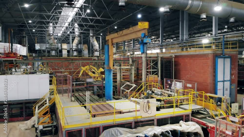 Robotic arm lifts equipment at a factory. Robotic arm lifts equipment at a factory.