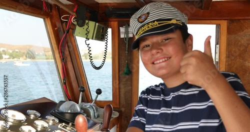 Young male skipper hands on a steering wheel of a boat motoring in mediterranean Sea