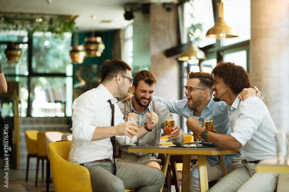 Friends are happy while watching game at te ub and drinking beer.