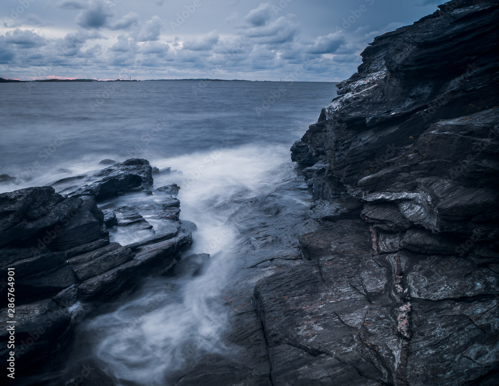 Fototapeta premium Waves hitting rocks with long exposure