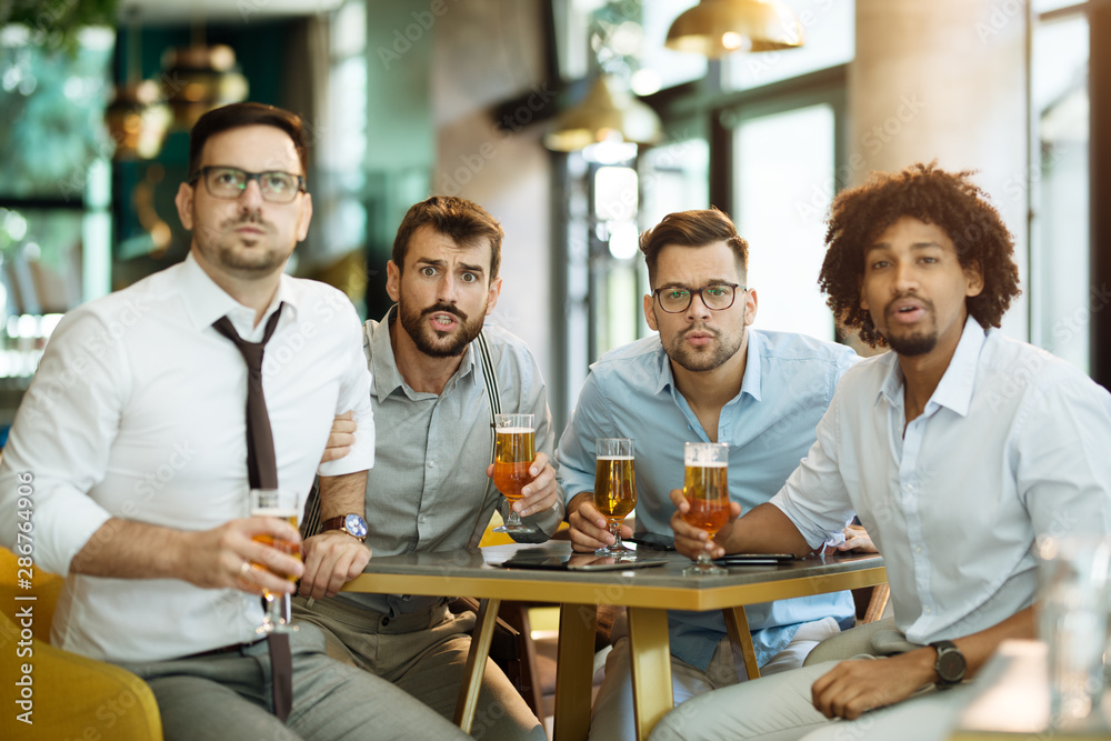 Friends are happy while watching game at te ub and drinking beer. Friends are happy while watching game at te ub and drinking beer.