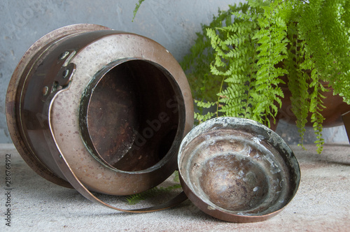 Antique copper kettle on concrete background.