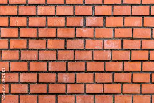 Closeup view of red brick well-built wall background.